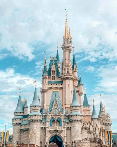Cinderella Castle at Magic Kingdom Park, Walt Disney World, photographed straight on from Main Street beneath a partly cloudy sky.